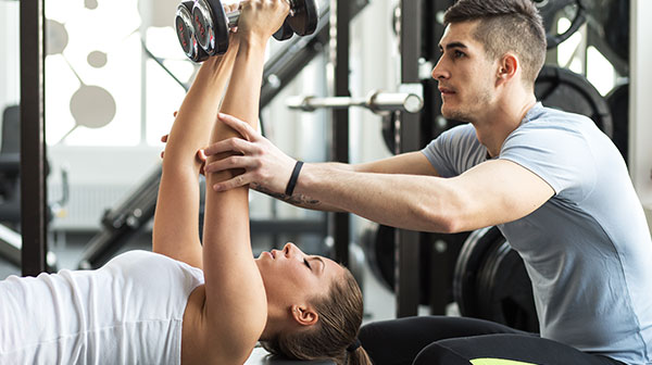 Fitness instructor helping client